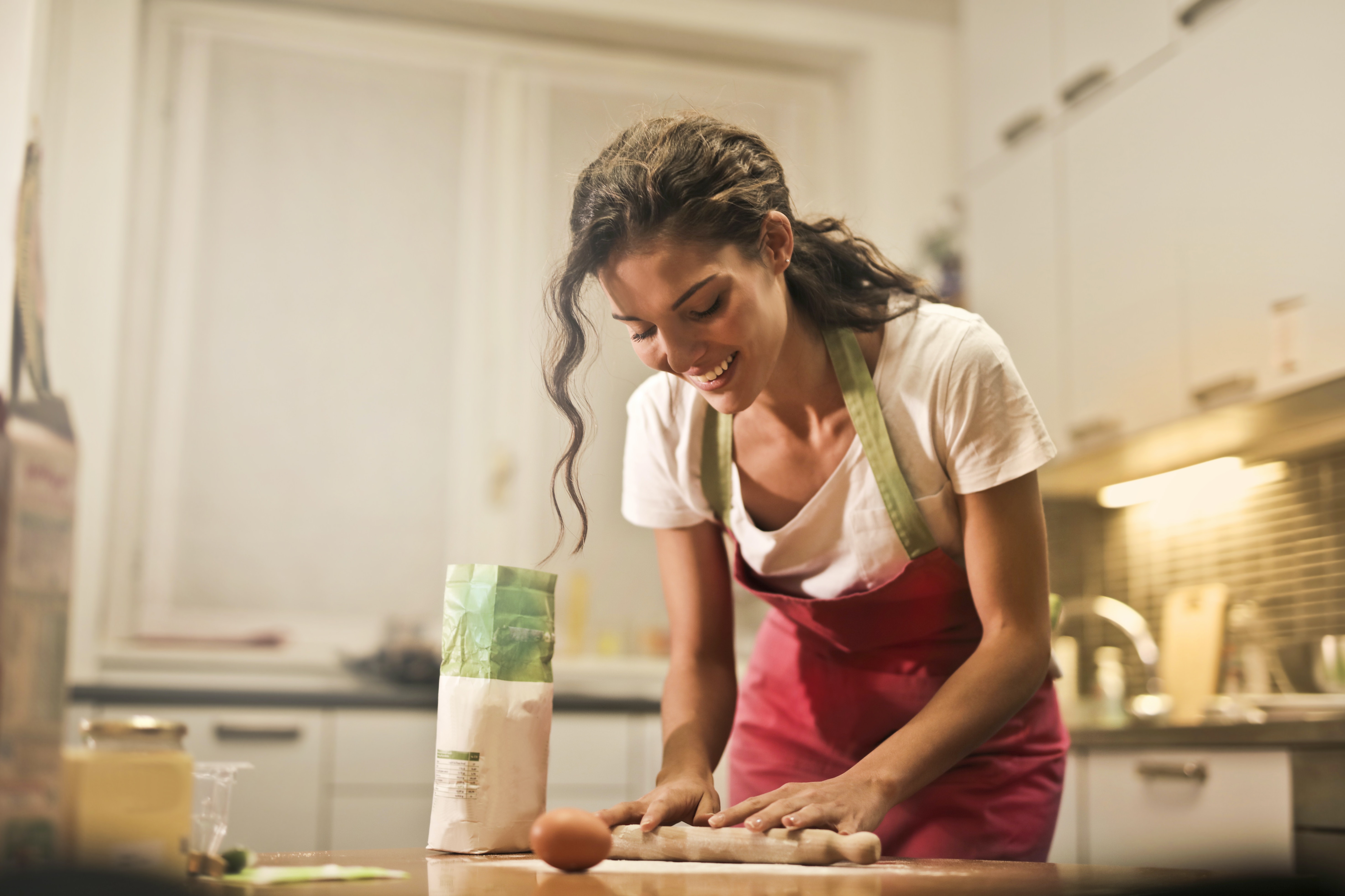 Female kneading dough in kitchen